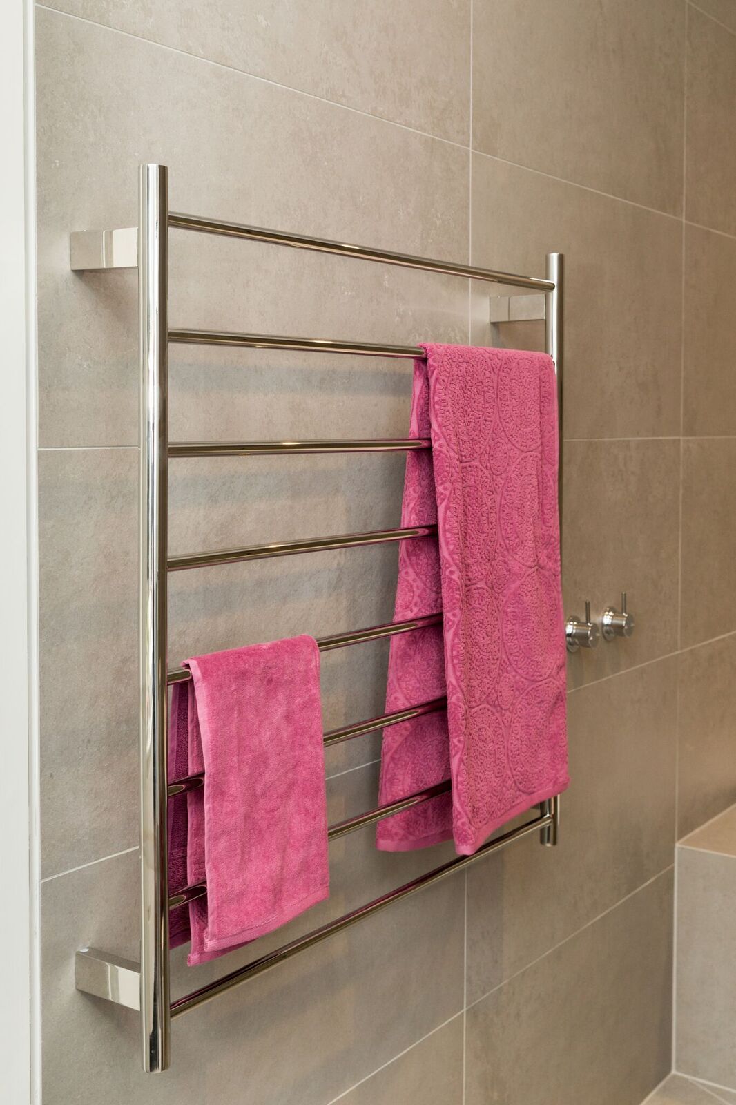 round-tube-towel-warmer-with-two-pink-towels